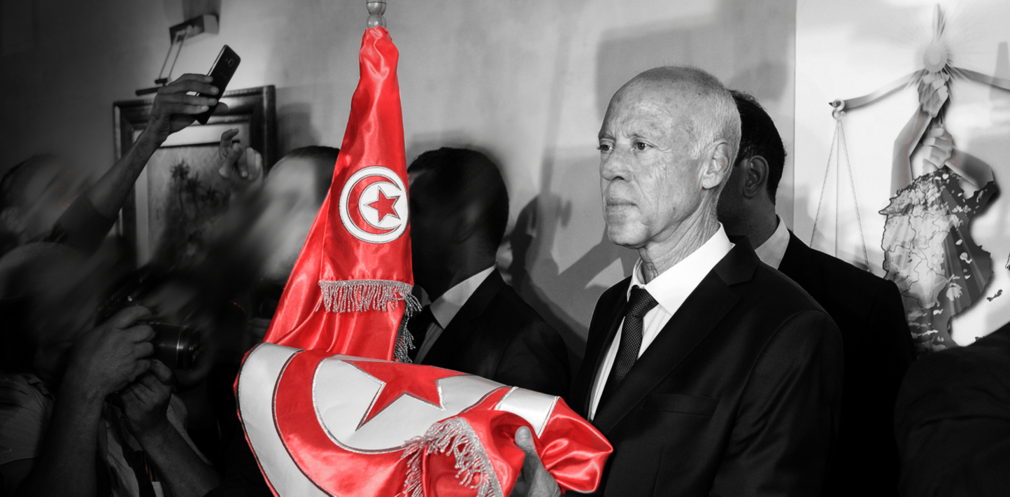 Le président tunisien Kaïs Saïed se tient à côté d'un drapeau de la Tunisie