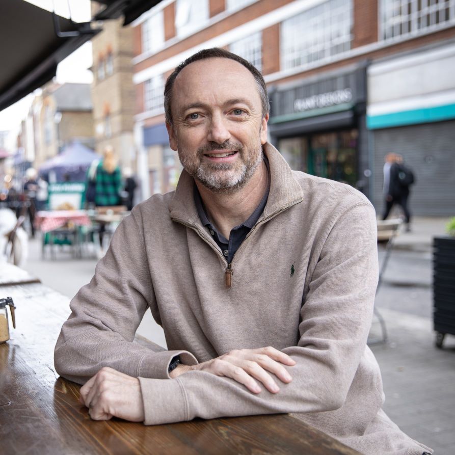 Laurent Sauveur sitting at a table outside.