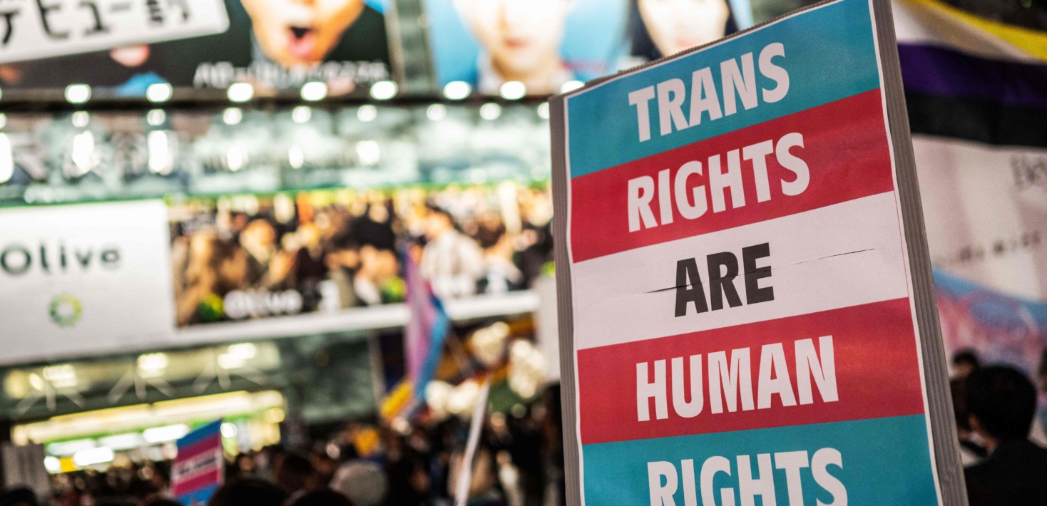 Une personne tient une pancarte indiquand "trans rights are human rights" (les droits des personnes trans sont des droits humains) lors d'une manifestation au Japon