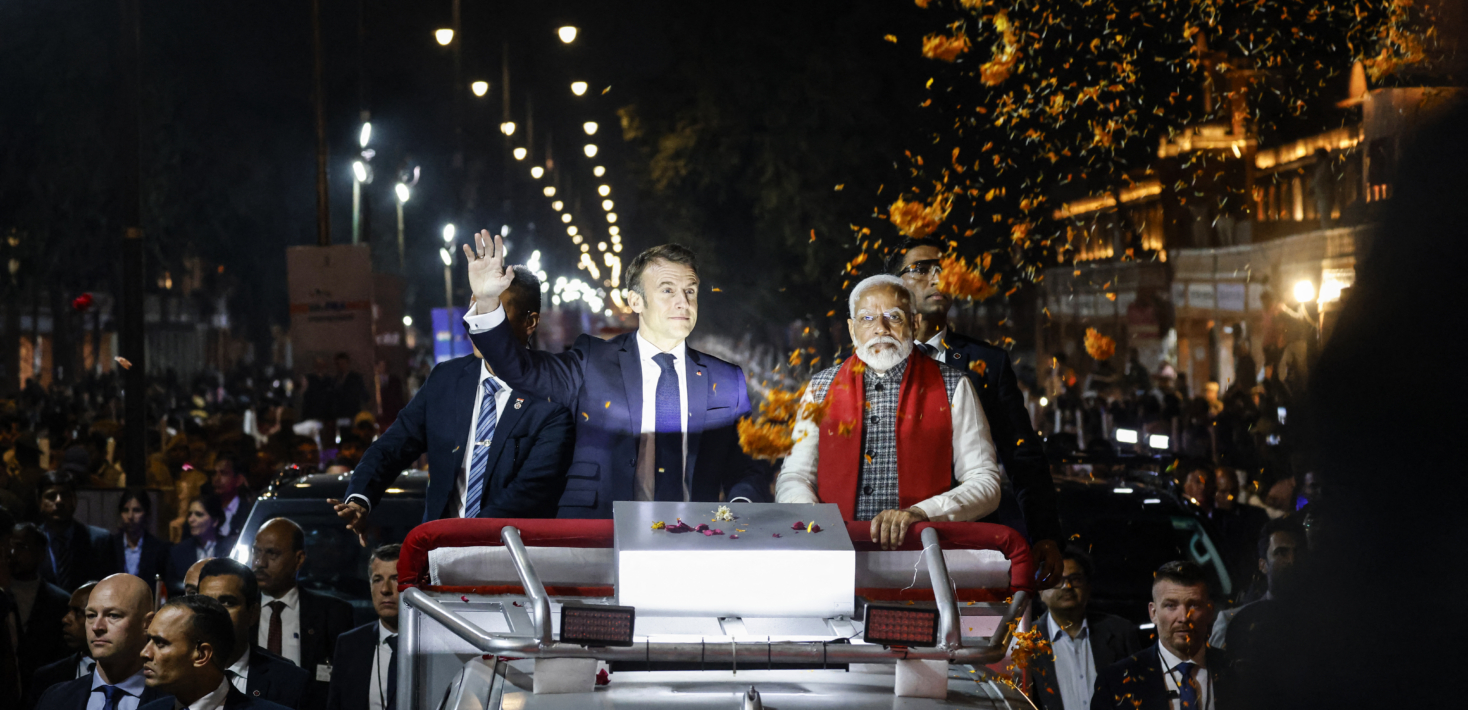 Emmanuel Macron (à gauche) et Narendra Modi (à droite) sont debout sur un véhicule lors d'un défilé et saluent la foule