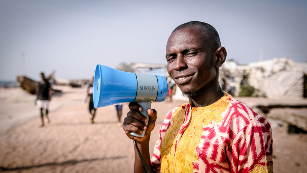 To raise awareness about gender-based violence in his community, Mohamed uses a megaphone