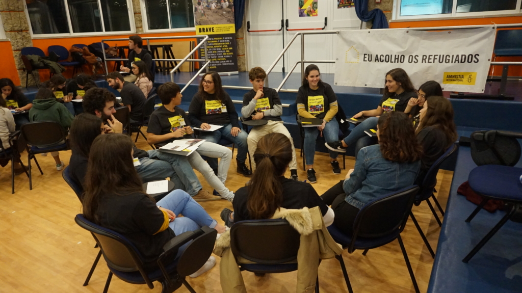 De jeunes militant·e·s assis en cercle participent aux échanges lors de la rencontre de l’an dernier au Portugal © Amnesty International Portugal