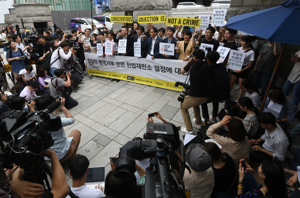 Des militants d'Amnesty rejoignent des objecteurs de conscience devant le Tribunal constitutionnel de Séoul le 28 juin. AFP/Getty