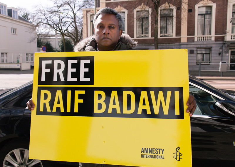 Le secrétaire général d’Amnesty International, Salil Shetty, devant l’ambassade saoudienne à la Haye, aux Pays-Bas, le 27 mars 2015. Plus d’un million de personnes dans le monde ont signé notre pétition pour demander la libération de Raif. © Jorn van Eck