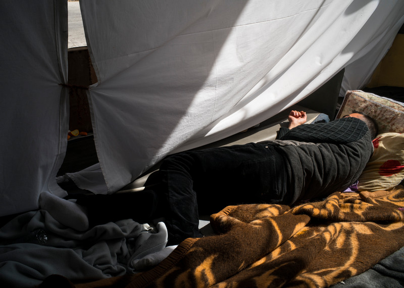 Masih est visiblement épuisé, stressé et exaspéré par la situation. « Tout le monde dort à même le sol dans le vieux terminal. Moi, je n’y dors pas - ça sent mauvais. » Il s’est plutôt construit un abri de fortune à l’extérieur. © Amnesty International/Olga Stefatou