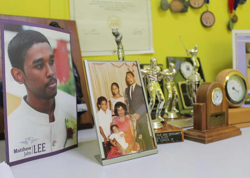 Une photo de Matthew Lee à côté d'un portrait de famille. Matthew a été tué par la police jamaïcaine en 2013.