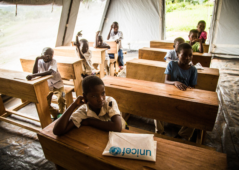 Des écoliers dans une tente faisant office de salle de classe provisoire montée par l'UNICEF dans le village de Mulombela, dans le Kasaï, en RDC. © UNICEF/UN0162334/Tremeau