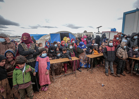 Personnes, majoritairement des enfants, portant des masques en tant que mesure de prévention contre le COVID-19 pendant que le département de la Santé d’Idlib et les équipes de défense civile, ainsi que des associations caritatives locales désinfectent des écoles et des villes de tentes à Idlib, Syrie, le 18 mars 2020. © Anadolu Agency/Getty Images