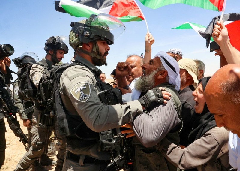 Israeli soldiers clash with Palestinian activists, holding Palestinian flags.