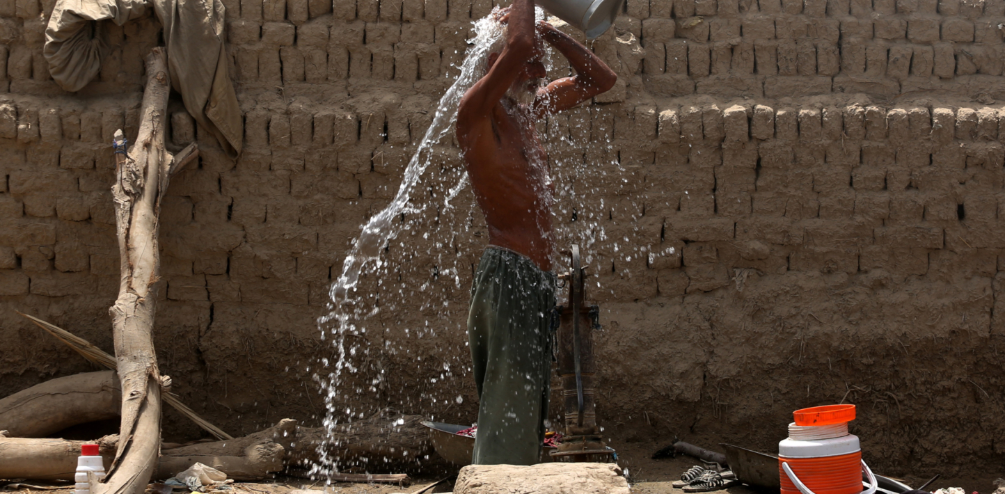 A man pouring water on himself to cool down from the searing heat