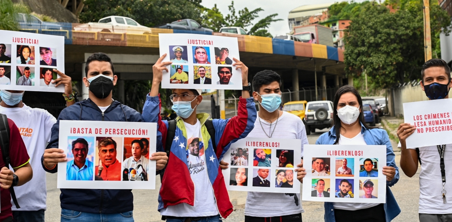 Relatives of political prisoners carry signs with pictures of them calling the attention of the Prosecutor of the International Criminal Court (ICC), Karim Khan, during a protest to demand their freedom in front of El Helicoide prison in Caracas, on November 3, 2021